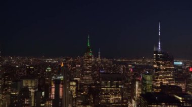 NEW YORK, ABD - 10 Mayıs 2024: Akşamları çarpıcı New York şehrinin siluetine bakın. Empire State Binası ve göz kamaştırıcı ışıklar görkemli bir şehir manzarası yaratır..