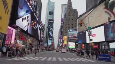 NEW YORK, ABD - 10 HAZİRAN 2025: Elektronik reklam panoları ve gökdelenler bulutlu günlerde bile Times Meydanı 'nı muhteşem bir şekilde aydınlatıyor