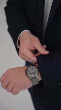 NEW YORK, ABD - 12 HAZİRAN 2025: Yakından çekilen bir fotoğrafta, bir adamın zarif saatinin altını çizerek özel dikim elbisesinin kolunu dikkatlice ayarladığı görülüyor.