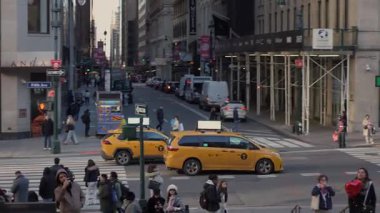 NEW YORK, ABD - 12 HAZİRAN 2025: Canlı bir şehir ortamında, sarı taksiler ve sayısız yayalar hareketli şehir sokaklarını enerjik enerjiyle dolduruyor