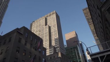 Parlak şehir ortamında açık mavi gökdelenlere karşı çarpıcı bir manzara ve hareketli bir hayat.