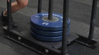NEW YORK, ABD - 4 Nisan 2025: Güç antrenmanlarında maksimum verimlilik için kızaklar üzerinde ağır mavi plakalar düzenleniyor
