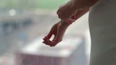 Bir gelin düğünden önce göz kamaştırıcı bileziğini ayarlar. Zarafet ve neşe saçar.