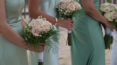 Nefis pastel buketler taşıyan bir grup zarif nedime şimdi güzel bir plaj düğün törenine hazır.