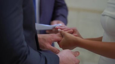 Sonsuz birlikteliklerini sembolize eden samimi bir tören sırasında bir çift yüzüklerini değiş tokuş ediyor.