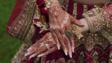 Güzel ve çetrefilli kına desenleri güzel süslenmiş elleri canlı ve renkli gelinliklerle süslenmiş.