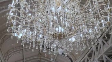 Karmaşık tasarımları ve ışıldayan kristalleriyle göz kamaştırıcı bir avize. Zarif boşluğu aydınlatıyor..