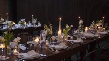 Hoş bir atmosfer için çiçek süslemeleri ve mum ışığı olan güzel bir yemek masası..