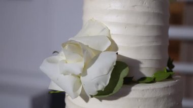 Nefis bir dörtlü düğün pastası zarif çiçeklerle süslenmiş ve yuvarlak bir masada yemyeşil.