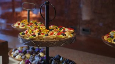 Etkinlik gösterimleri için katlarda zarif bir şekilde düzenlenmiş lezzetli hamur işleri ve tatlılardan oluşan renkli bir karışım
