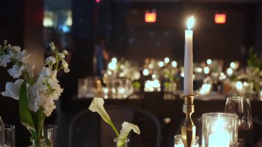 Özel bir kutlama için nefis bir şekilde taze çiçeklerle süslenmiş mum ışığında yemek masası.