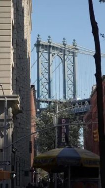 NEW YORK, ABD - 22 Nisan 2025 Dinamik kentsel mimari ve canlı yeşillik tarafından çerçevelenmiş Manhattan Köprüsü 'nün çarpıcı bir görüntüsü