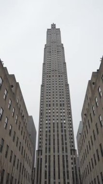 Uçsuz bucaksız şehir manzarasının üzerinde, kasvetli bir bulutlu gökyüzüne karşı kurulmuş çarpıcı görkemli gökdelen kuleleri.