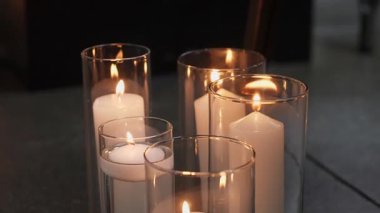 Cam tutacaklarda yanan mumlardan oluşan sakin bir düzenleme, sıcak ve davetkar bir atmosfer yaratmak için mükemmel..