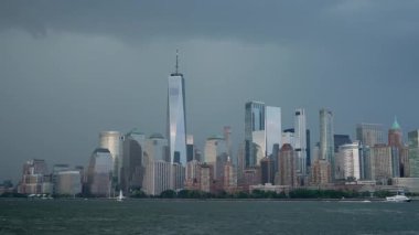 NEW YORK, ABD - 12 Temmuz 2025: Durgun gökyüzünün altında dinamik bulutlarla birlikte sakin sulara yansıyan çarpıcı bir şehir silueti güzellik ve entrika yaratıyor
