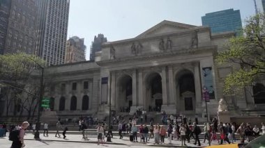 NEW YORK, ABD - 17 Nisan 2025: Güneşli bir günde, büyük bir kalabalık New York Halk Kütüphanesi 'nin çarpıcı mimarisini takdir etmek için toplandı