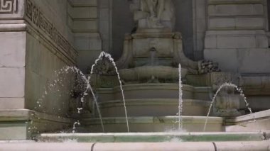 Güzel bir su çeşmesinin nefes kesici ve çarpıcı görüntüsü klasik mimarinin zengin arkaplanına karşı kurulmuş.
