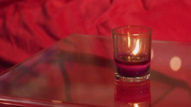 Huzurlu bir mum nazikçe yanar, sıcak renkleri yansıtır ve derinlemesine sakin ve huzurlu bir ortamda