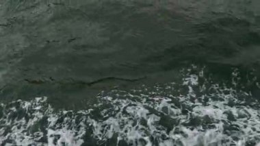 Okyanus dalgalarının büyüleyici görüntüsü, eşsiz köpüklü bir dokuya ve suların davetkar koyu yeşil rengine sahip