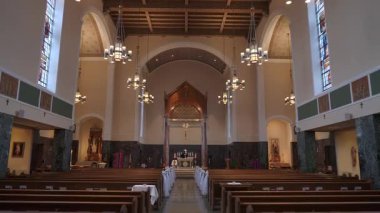 Kilisenin içi nefes kesici bir manzaraya sahip, etkileyici ahşap kirişler ve renkli camlar var.