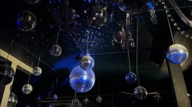 Tavandan sarkan parlak disko toplarının büyüleyici görüntüsü, gece hayatı görselleri için mükemmel..