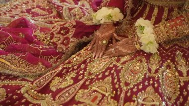 Şatafatlı kıyafetlerle süslenmiş nefes kesici bir gelin, güzel, karmaşık gelenekler ve canlı çiçeklerle süslenmiş bir gelin.