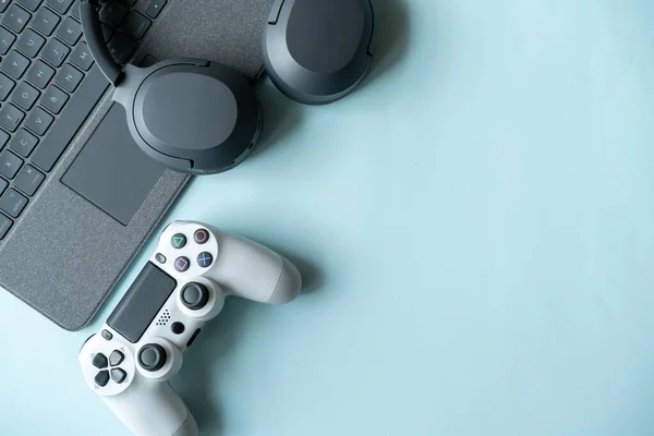Top view of gaming background with joystick and gamepad, game console, headphones with accessories on blue background ,Online learning design concept. Top view of  ,Top view with copy space for text
