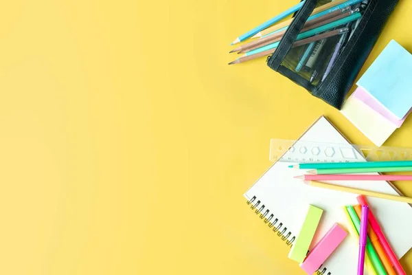 トップビュー写真 学校の概念に戻って 学校の文房具 色鉛筆 ペンキ テキストのためのコピースペースが付いている隔離された黄色の背景のメモ帳が付いている平らな組成 — ストック写真