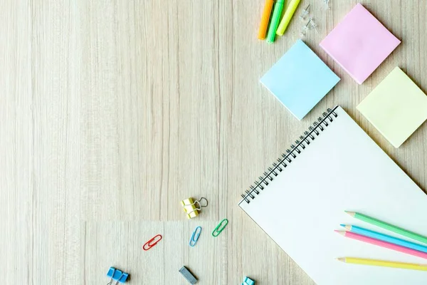 上视图照片 回到学校概念 平面布局作文与学校文具 彩色铅笔 笔记在孤立的木材背景与复制空间的文字 — 图库照片#