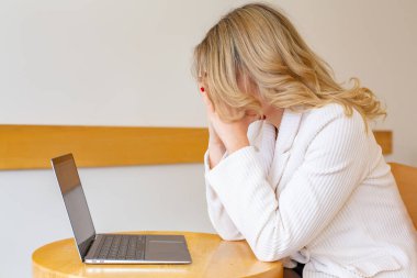 Güzel kız bilgisayarını kullanırken ve uzaktan çalışırken kendini yorgun ve stresli hissediyor. Ofisteki iş kadını depresyonda.. 