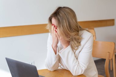 Güzel kız bilgisayarını kullanırken ve uzaktan çalışırken kendini yorgun ve stresli hissediyor. Ofisteki iş kadını depresyonda.. 