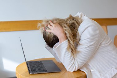 Güzel kız bilgisayarını kullanırken ve uzaktan çalışırken kendini yorgun ve stresli hissediyor. Ofisteki iş kadını depresyonda.. 