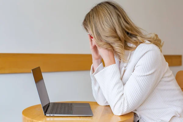 stock image Beautiful girl freelancer feeling tired and stressed while using a laptop and working remotely from home. Business woman at the office is depressed. 