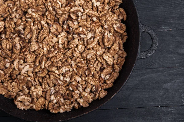 stock image Walnut background. Peeled walnuts on a iron plate on black. walnuts a real super food full of vitamins and vegetable fats