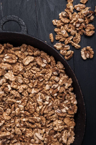 stock image Walnut background. Peeled walnuts on a iron plate on black. walnuts a real super food full of vitamins and vegetable fats