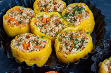 Doldurulmuş biber. Biberli pilav ve kıyma. Siyah arka planda, dökme demir bir tavada pişmiş biber. Sağlıklı Romanya yemekleri.