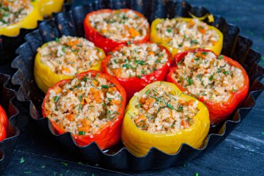 Doldurulmuş biber. Biberli pilav ve kıyma. Siyah arka planda, dökme demir bir tavada pişmiş biber. Sağlıklı Romanya yemekleri.