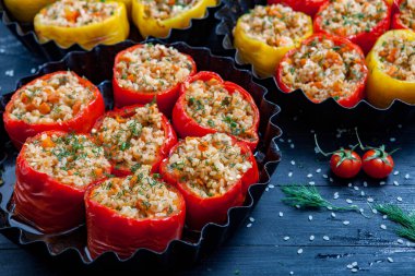 Doldurulmuş biber. Biberli pilav ve kıyma. Siyah arka planda, dökme demir bir tavada pişmiş biber. Sağlıklı Romanya yemekleri.