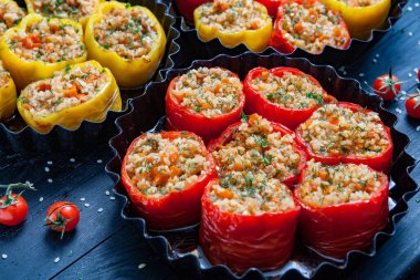 Doldurulmuş biber. Biberli pilav ve kıyma. Siyah arka planda, dökme demir bir tavada pişmiş biber. Sağlıklı Romanya yemekleri.