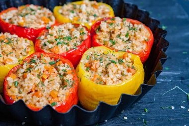 Doldurulmuş biber. Biberli pilav ve kıyma. Siyah arka planda, dökme demir bir tavada pişmiş biber. Sağlıklı Romanya yemekleri.