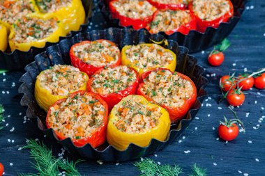 Doldurulmuş biber. Biberli pilav ve kıyma. Siyah arka planda, dökme demir bir tavada pişmiş biber. Sağlıklı Romanya yemekleri.