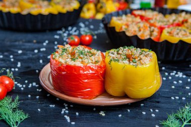 Doldurulmuş biber. Biberli pilav ve kıyma. Siyah arka planda, dökme demir bir tavada pişmiş biber. Sağlıklı Romanya yemekleri.