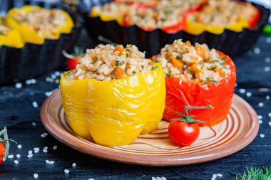 Doldurulmuş biber. Biberli pilav ve kıyma. Siyah arka planda, dökme demir bir tavada pişmiş biber. Sağlıklı Romanya yemekleri.