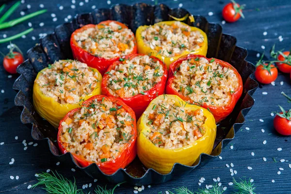 Doldurulmuş biber. Biberli pilav ve kıyma. Siyah arka planda, dökme demir bir tavada pişmiş biber. Sağlıklı Romanya yemekleri.