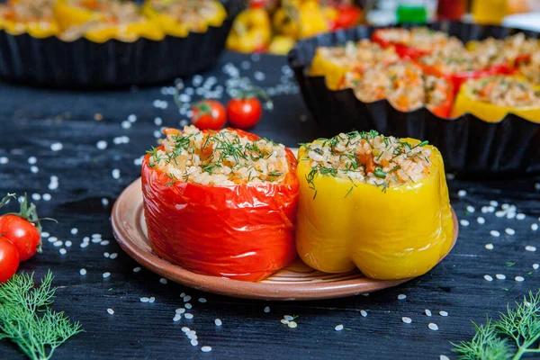 Doldurulmuş biber. Biberli pilav ve kıyma. Siyah arka planda, dökme demir bir tavada pişmiş biber. Sağlıklı Romanya yemekleri.