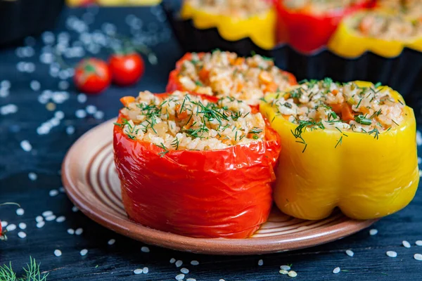 stock image Stuffed pepper. Stewed pepper with rice and minced meat. Baked peppers in a cast iron pan on a black background. Healthy Romanian food.