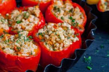 Doldurulmuş biber. Biberli pilav ve kıyma. Siyah arka planda, dökme demir bir tavada pişmiş biber. Sağlıklı Romanya yemekleri.