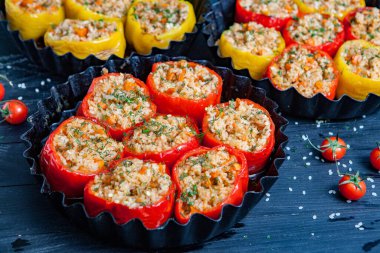 Doldurulmuş biber. Biberli pilav ve kıyma. Siyah arka planda, dökme demir bir tavada pişmiş biber. Sağlıklı Romanya yemekleri.