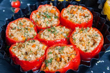 Doldurulmuş biber. Biberli pilav ve kıyma. Siyah arka planda, dökme demir bir tavada pişmiş biber. Sağlıklı Romanya yemekleri.