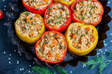 Doldurulmuş biber. Biberli pilav ve kıyma. Siyah arka planda, dökme demir bir tavada pişmiş biber. Sağlıklı Romanya yemekleri.